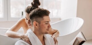 Romantyczne książki na prezent: jak wybrać powieść, która trafi prosto w serce Para w wannie czytająca książkę i tuląca się romantycznie